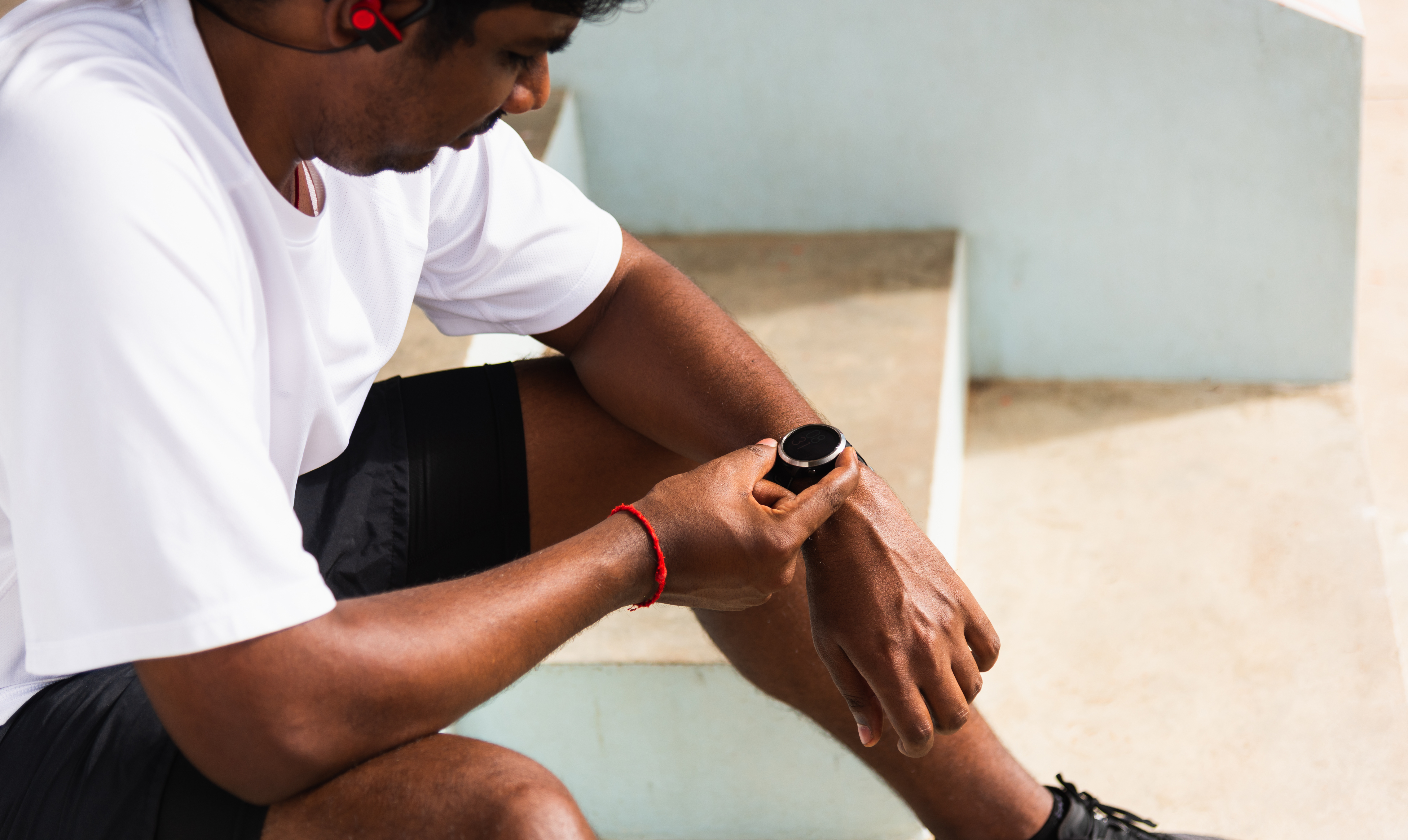 sport runner black man wear modern time smart watch he sitting resting